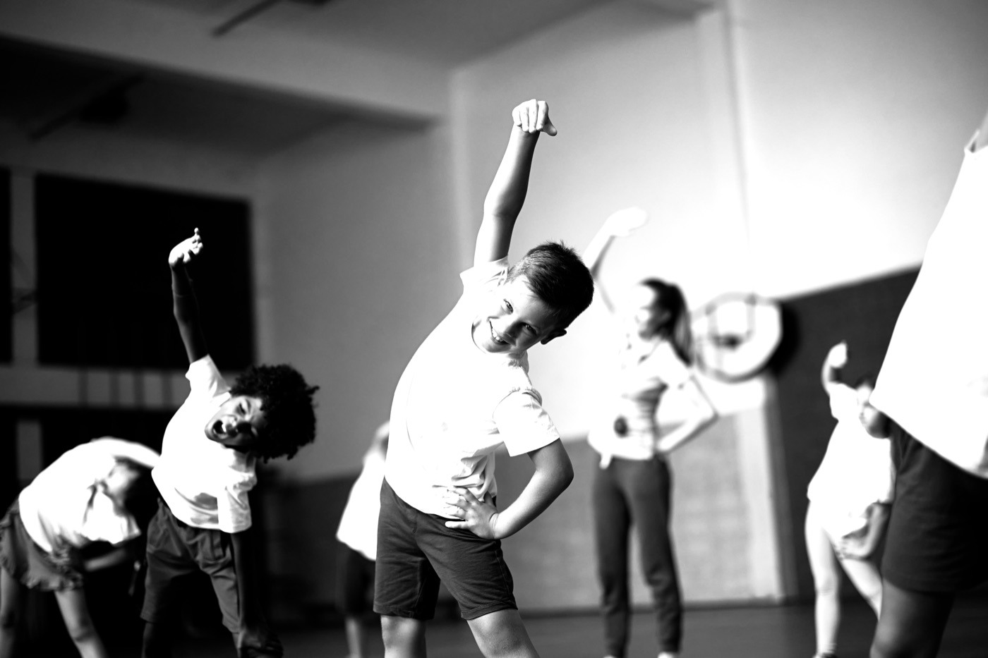 Children stretching arms overhead during a dance class