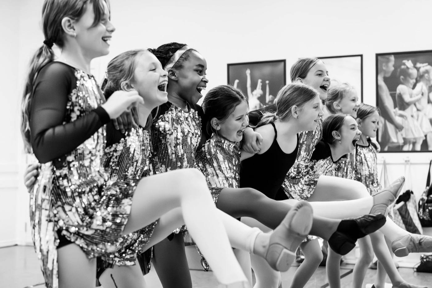 Group of young dancers in sequined costumes laughing together